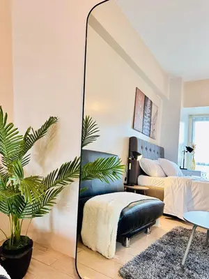 a living room with a mirror and a couch at 81 Newport Urban Chic Studio near NAIA Terminal 3 in Manila
