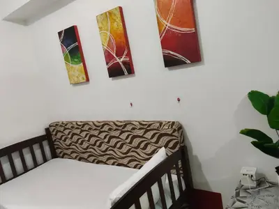 a staircase with four paintings on the wall at Sea Residences Anna Staycation in Manila