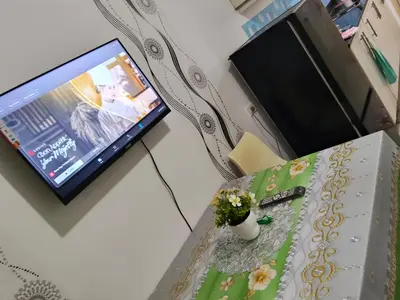 a living room with a table with a television and a table sidx sidx at Sea Residences Anna Staycation in Manila
