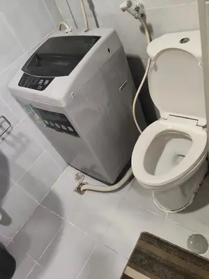 a printer in a bathroom with a toilet at Sea Residences Anna Staycation in Manila
