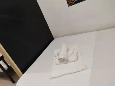 a pair of white shoes sitting on a bed at Sea Residences Anna Staycation in Manila