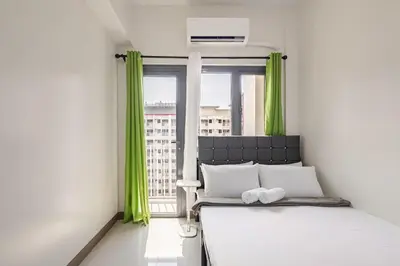 a bedroom with a bed and a window with green curtains at Near SM BF & Shopwise SLEX Accessible 2BR for 4 in Manila