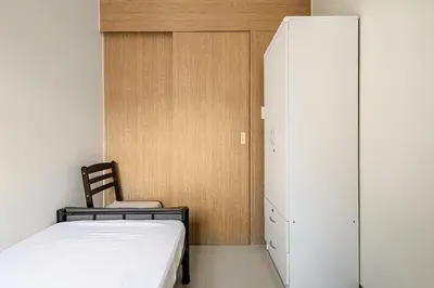 a bedroom with a bed and a white cabinet at Near SM BF & Shopwise SLEX Accessible 2BR for 4 in Manila