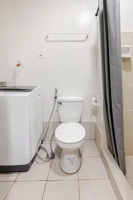 a bathroom with a white toilet in a room at Near SM BF & Shopwise SLEX Accessible 2BR for 4 in Manila