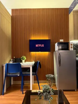 a kitchen with a table and blue chairs and a refrigerator at S&B rentals in Manila
