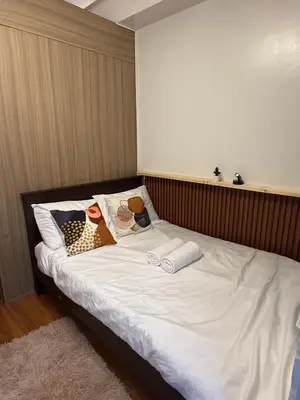 a bed with white sheets and pillows on it at S&B rentals in Manila