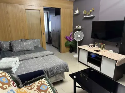 a bedroom with a bed and a desk with a flat screen tv at Shell residence Family room by Kathy in Manila