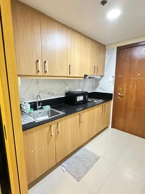 a kitchen with wooden cabinets and a sink at Shell residence Family room by Kathy in Manila