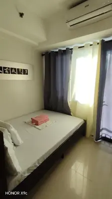 a small bedroom with a bed and a window at Moana SEA RESIDENCE condotel in Manila