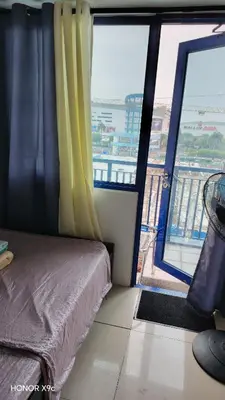 a bedroom with a bed and a large window at Moana SEA RESIDENCE condotel in Manila