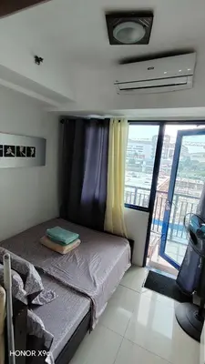 a bedroom with a bed and a window with a view at Moana SEA RESIDENCE condotel in Manila