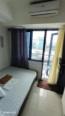 a small bedroom with a bed and a large window at Moana SEA RESIDENCE condotel in Manila