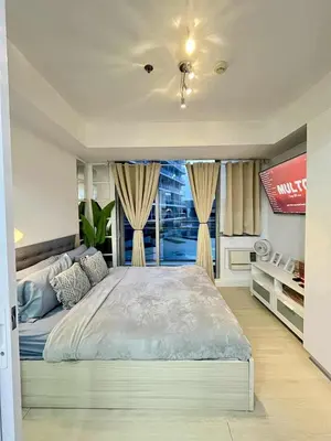 a bedroom with a large bed and a window at Panglao Staycation in Manila