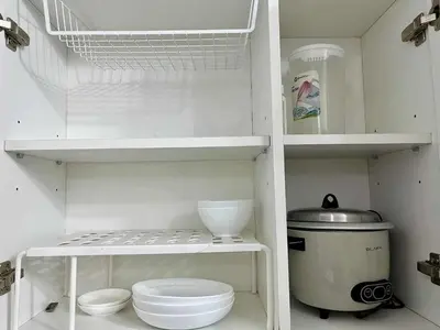 a white kitchen with white shelves and a sink at Panglao Staycation in Manila