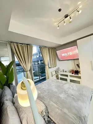 a living room with a couch and a television at Panglao Staycation in Manila