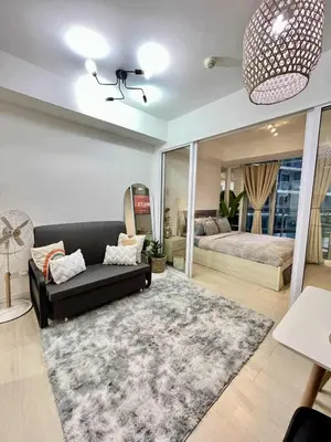 a living room with a couch and a bed at Panglao Staycation in Manila