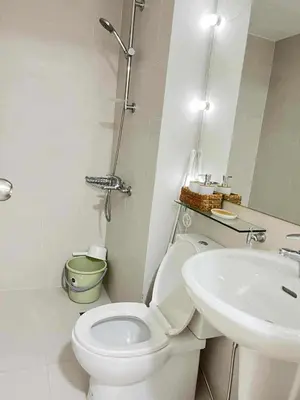 a white bathroom with a toilet and a sink at Panglao Staycation in Manila