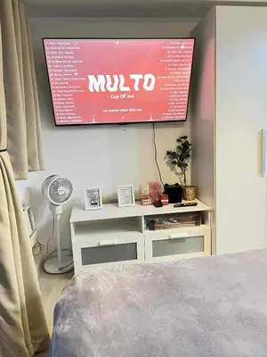 a tv hanging on a wall in a bedroom at Panglao Staycation in Manila