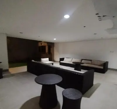 a living room with a couch and a table and stools at S Residences MOA by darpm in Manila