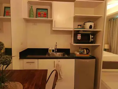 a kitchen with a sink and a counter top at COZY COVE IN venice MCKINLEY HILL in Manila