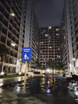 a blue sign in front of some buildings at night at Shore 2 in Manila