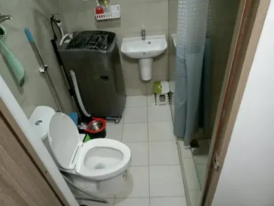 a small bathroom with a toilet and a sink at Shore 2 in Manila