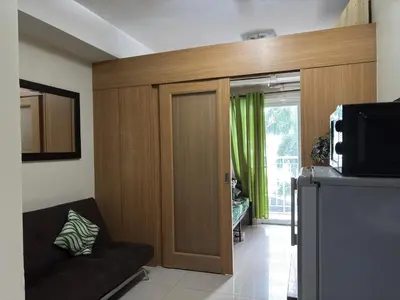 a living room with a couch and a sliding door at Ate Aby's Place 338 in Manila