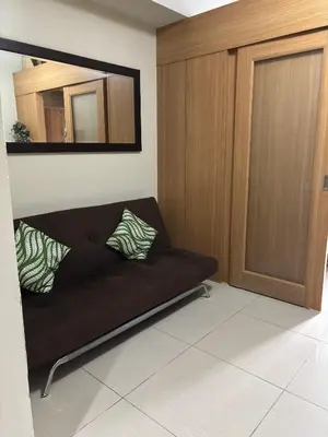 a black couch in a living room with a mirror at Ate Aby's Place 338 in Manila