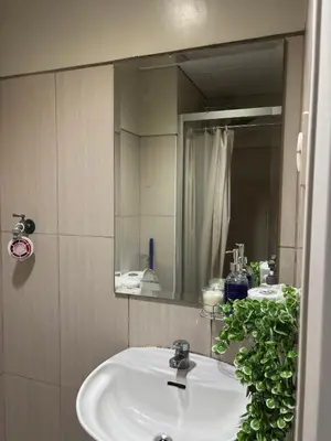 a bathroom with a white sink and a mirror at Ate Aby's Place 338 in Manila