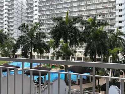 a balcony with palm trees and a large apartment building at Ate Aby's Place 338 in Manila