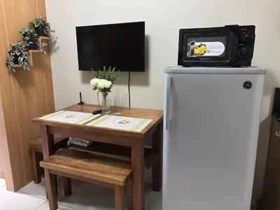 a small table with a refrigerator and a tv at Ate Aby's Place 338 in Manila