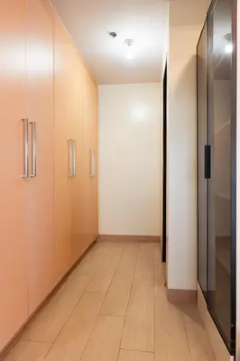 an empty hallway with wooden cabinets and a hardwood floor at Elegant 3 Bedroom unit with Ocean View near Okada in Manila