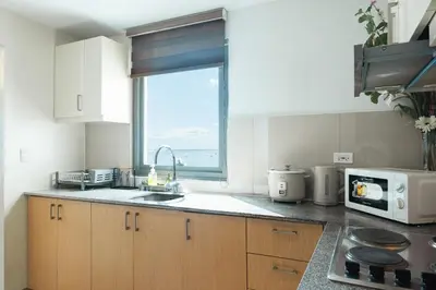 a kitchen with a sink and a microwave and a window at Elegant 3 Bedroom unit with Ocean View near Okada in Manila