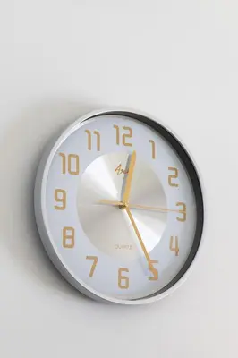 a clock is hanging on a white wall at Peaceful & Calm 1BR Studio l Near MOA, SMX & NAIA in Manila