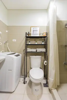 a bathroom with a toilet and a shower and a sink at Peaceful & Calm 1BR Studio l Near MOA, SMX & NAIA in Manila