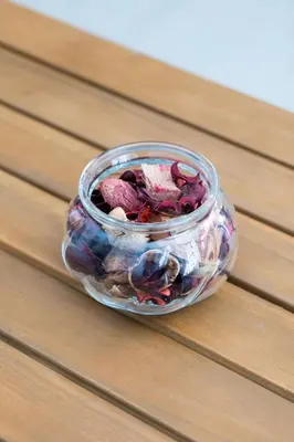 a glass jar filled with dried flowers on a wooden table at Peaceful & Calm 1BR Studio l Near MOA, SMX & NAIA in Manila
