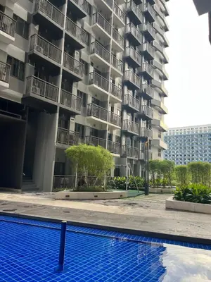 an apartment building with a swimming pool in front of it at Queen Bed with Coffee Bar and Fast Wi-Fi at S Residences in Manila