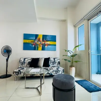 a living room with a couch and a glass table at Luxe 1BR BGC with Balcony in Manila