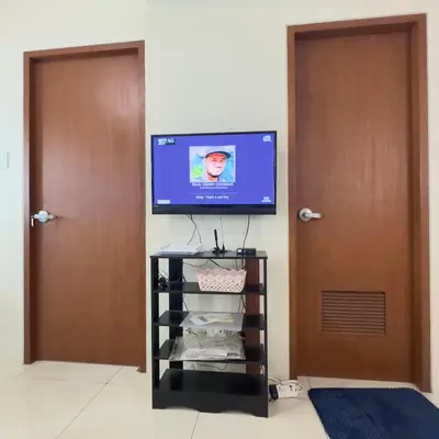 a television sitting on top of a tv stand in a room at Luxe 1BR BGC with Balcony in Manila
