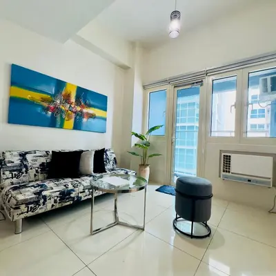 a living room with a couch and a glass table at Luxe 1BR BGC with Balcony in Manila