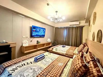 a bedroom with two beds and a flat screen tv at Moments Staycations in Manila