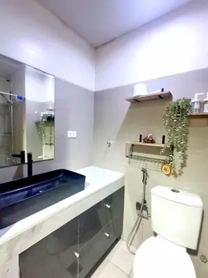 a bathroom with a blue sink and a toilet at Moments Staycations in Manila