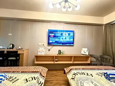 a hotel room with two beds and a tv on the wall at Moments Staycations in Manila