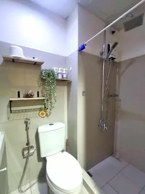a bathroom with a toilet and a shower at Moments Staycations in Manila