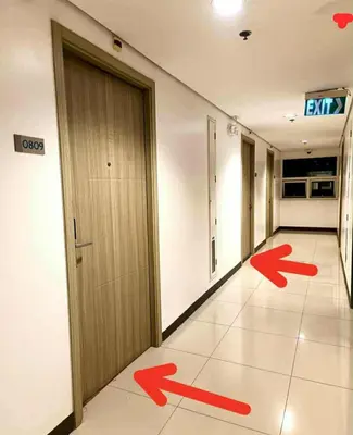 a hallway with a door and red arrows on the floor at Moments Staycations in Manila