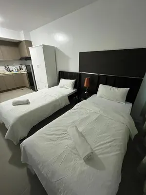two beds in a room with white sheets at The Serenity Tower 2011 in Manila