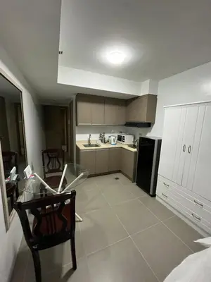 a small kitchen with a table and a refrigerator at The Serenity Tower 2011 in Manila