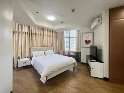 a bedroom with a white bed and a window at Mandala Stays - The Family Suite in Manila