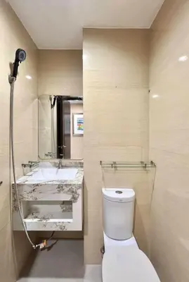 a bathroom with a toilet and a sink at Mandala Stays - The Family Suite in Manila