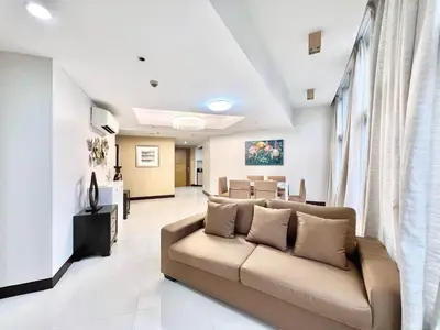 a living room with a couch and a dining room at Mandala Stays - The Family Suite in Manila